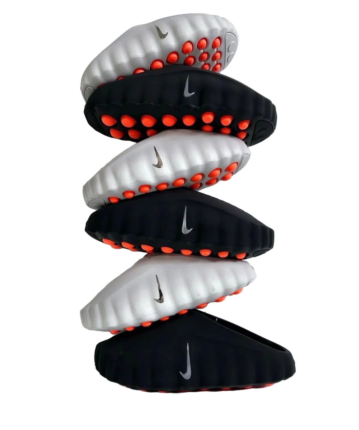 Stack of black and white sandals with red accents on a light gray background